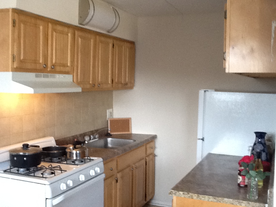 Kitchen with granite countertops, beige tile backsplash, and white appliances